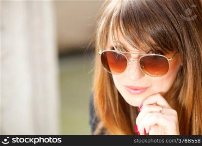 Portrait pretty thoughtful woman in sunglasses outdoors on the street
