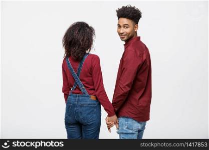Portrait rear view of young afro american couple holding hands isolated on white background.. Portrait rear view of young afro american couple holding hands isolated on white background