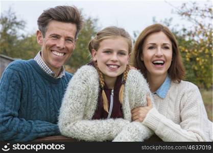 Portrait shot of an attractive, successful and happy family, man, woman, girl child, mother, father and daughter outside in Fall or Autumn