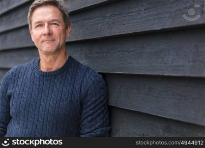 Portrait shot of an attractive, successful and happy middle aged man male outside wearing a blue sweater