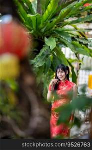 Portrait smiles Asian transgender woman wearing red cheongsam dress traditional decoration for Chinese new year festival celebrate culture of china at Chinese shrine Public places in Thailand