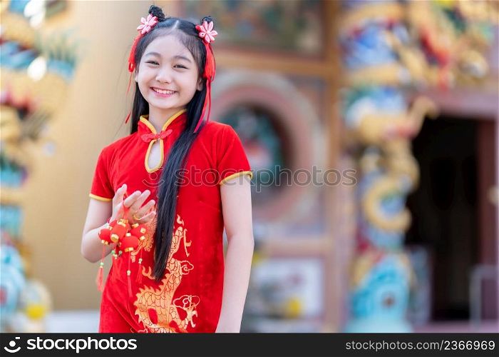 Portrait smiles Cute little Asian woman wearing red traditional Chinese cheongsam decoration hold Small lantern decorations for Chinese New Year