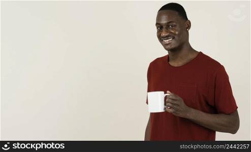 portrait smiley man t shirt holding mug with copy space