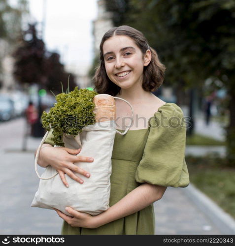 portrait smiley woman carrying groceries