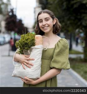 portrait smiley woman carrying groceries