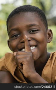 portrait smiley young african boy doing silent sign