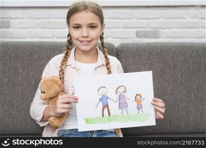 portrait smiling girl sitting sofa showing her family drawing paper