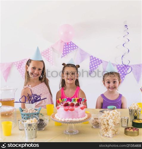 portrait smiling kids wearing party hat celebrating birthday party