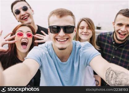 portrait smiling man taking selfie with friends