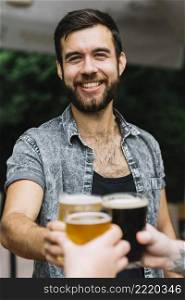 portrait smiling man toasting glasses beer glasses with his friend