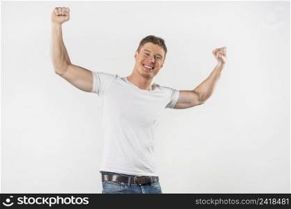 portrait smiling muscular man clenching her fist against white backdrop