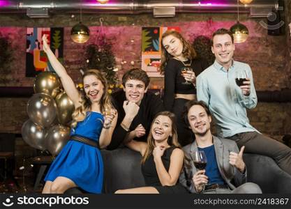 portrait smiling young couples holding wine glasses enjoying party