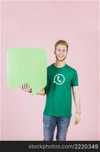 portrait smiling young man holding empty green speech bubble