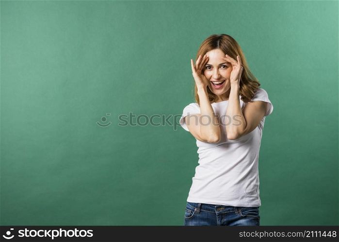 portrait smiling young woman against green backdrop