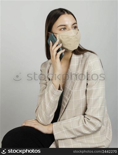portrait stylish woman with mask using mobile 2