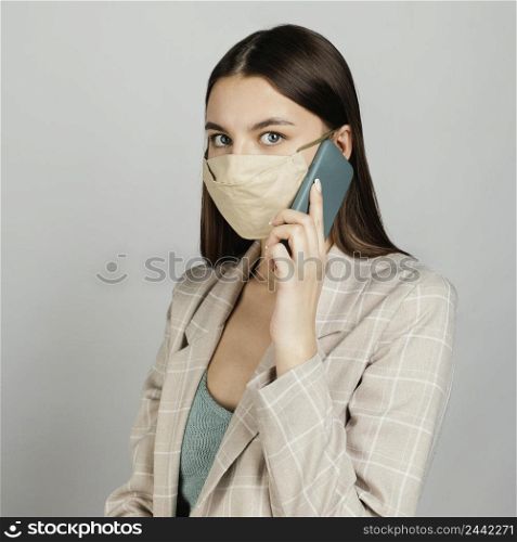 portrait stylish woman with mask using mobile 3