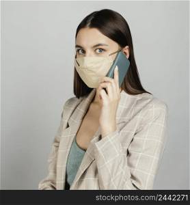 portrait stylish woman with mask using mobile 3