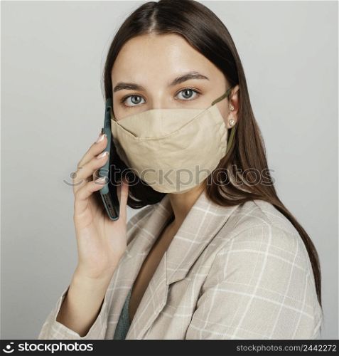 portrait stylish woman with mask using mobile 4