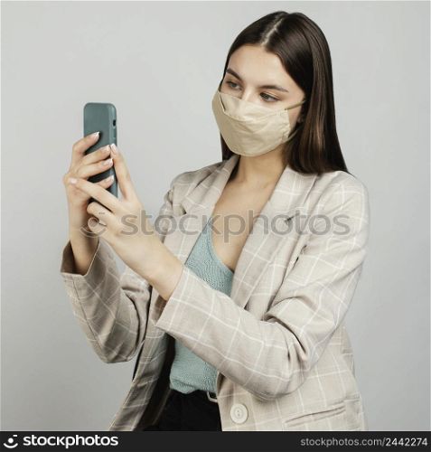 portrait stylish woman with mask using mobile 6