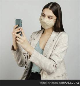 portrait stylish woman with mask using mobile 6
