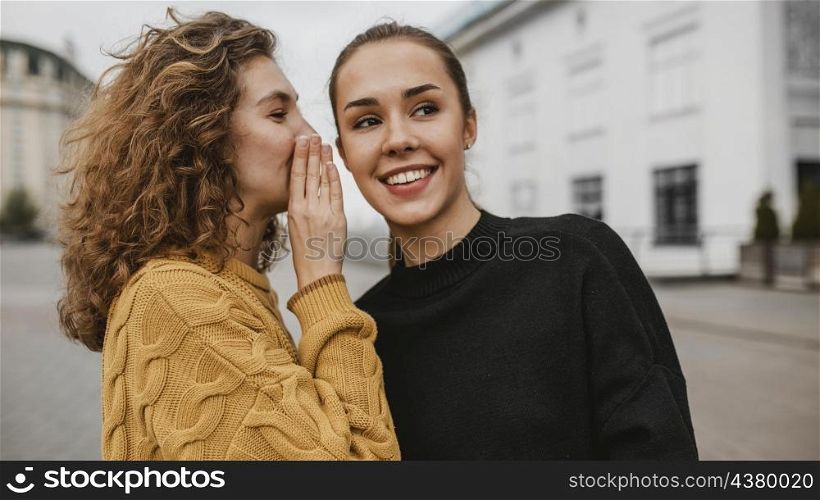 portrait teenager whispering her friends ear