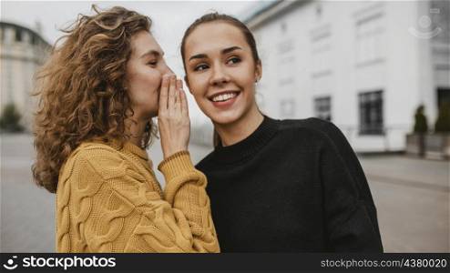 portrait teenager whispering her friends ear