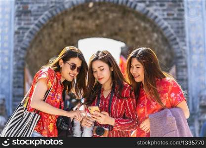 Portrait Three asian happiness women using smart mobile phone for social network together when travelling over the Lijiang old town, China, travel and tourism with friendship concept