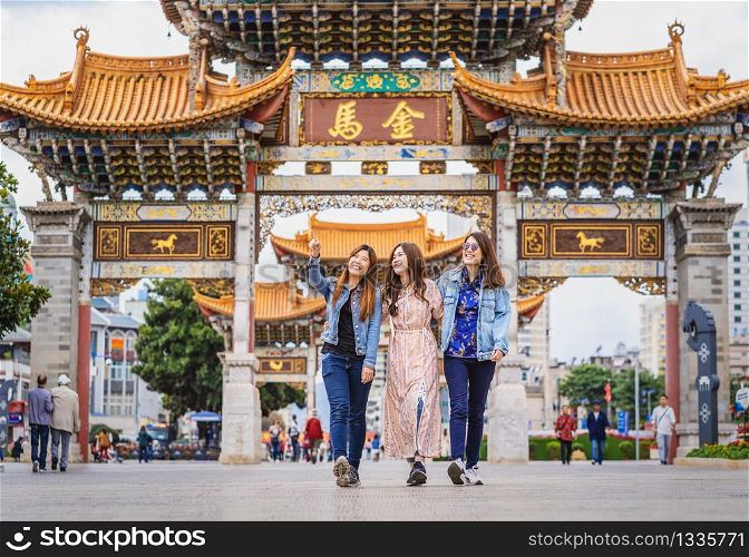 Portrait Three asian happiness women walking and sightseeing together when travelling over the Jinbi square, Kunming, China, travel and tourism with friendship concept,Chinese Text is Golden Horse