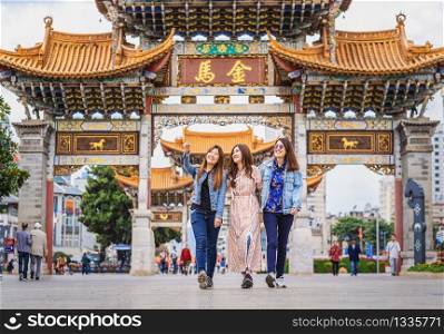 Portrait Three asian happiness women walking and sightseeing together when travelling over the Jinbi square, Kunming, China, travel and tourism with friendship concept,Chinese Text is Golden Horse