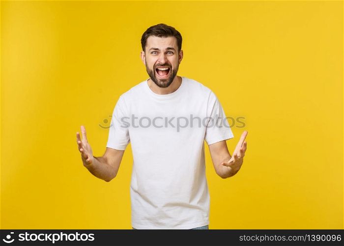 Portrait unhappy handsome man looking at camera on yellow background. Portrait unhappy handsome man looking at camera on yellow background.
