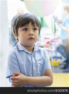 Portrait upset little boy standing alone and start crying at birthday party, Unhappy Caucasian 6 year old child at the party, Lonely kid with bored face, Jealous children concept.