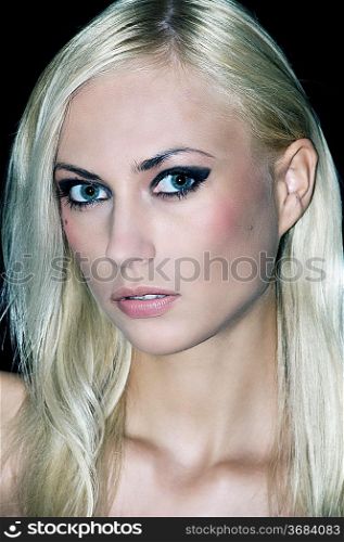 portrait with only the camera light of a nice blond looking in camera with strong make up