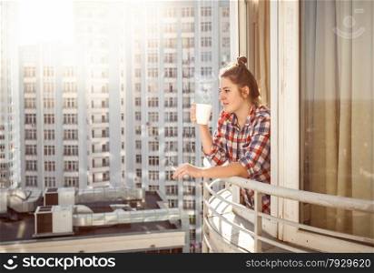 Portrait woman drinking coffee and smoking out of window