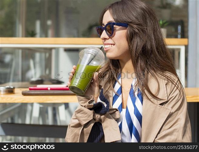 portrait woman drinking green smoothie