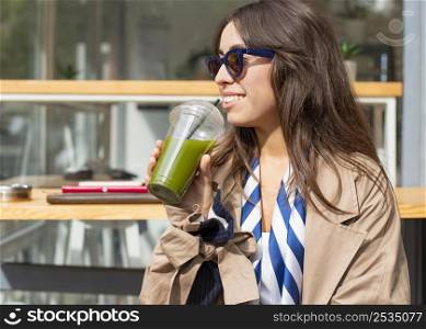 portrait woman drinking green smoothie