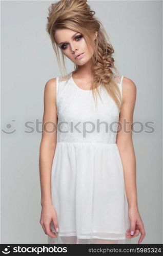 Portrait woman with creative hairstyle and in a white dress.
