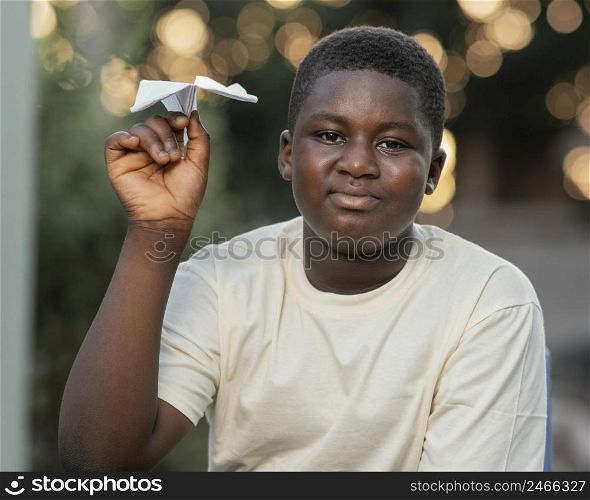 portrait young african boy playing with airplane