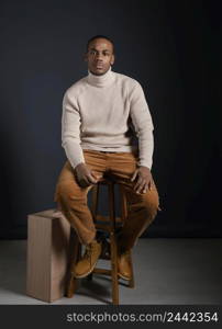 portrait young african man sitting chair