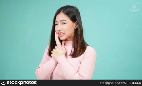 Portrait young Asian beautiful woman wear silicone orthodontic retainers on teeth feeling pain toothache holding her cheek with hand isolated on blue background. Female suffering teeth pain dental