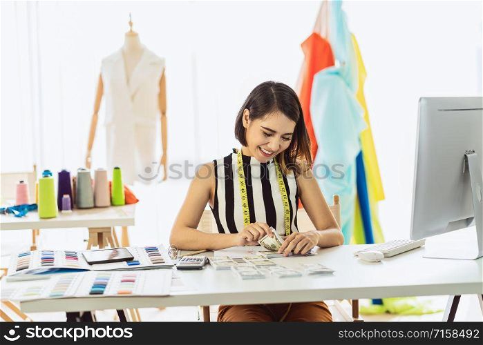 Portrait Young Asian Designer woman working and Counting money at workplace, small business startup,Business owner entrepreneur, investment and profit, freelance job lifestyle concept.asean people
