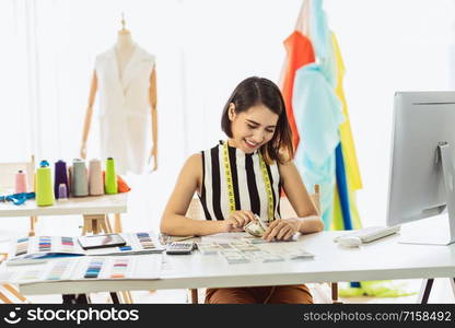 Portrait Young Asian Designer woman working and Counting money at workplace, small business startup,Business owner entrepreneur, investment and profit, freelance job lifestyle concept.asean people