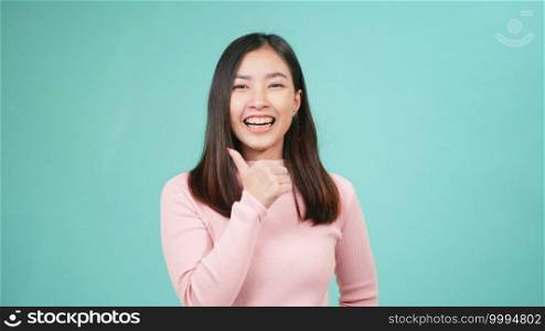 Portrait young Asian happy beautiful woman smiling wear silicone orthodontic retainers on teeth showing thumb up finger isolated on blue background. Dental hygiene and health concept