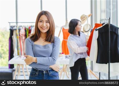 Portrait Young Asian SME Business owner happy smile with her new clothing shop grand opening day promotion and customer care.