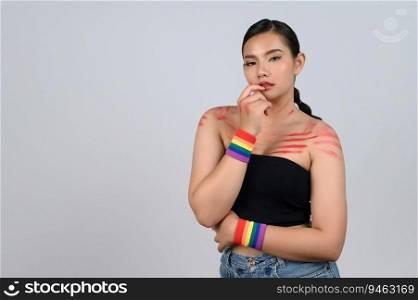 Portrait young asian woman with red lipstick mark on her face and body in sexy clothing with Multi-colored wristbands on her wrist in concept LGBQ on white background
