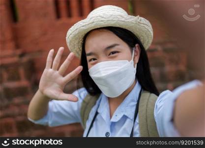 Portrait young backpacker female wearing protection mask and hat traveling in ancient site, She Self portrait of playful with happiness, copy space