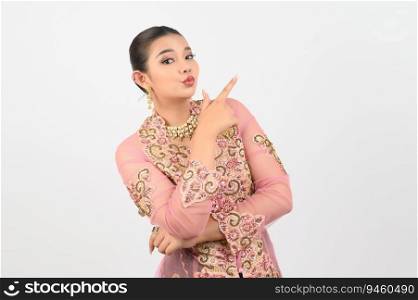 Portrait Young beautiful woman dress up in local culture in southern region with charming gesture smile and point finger out on copy space of white background