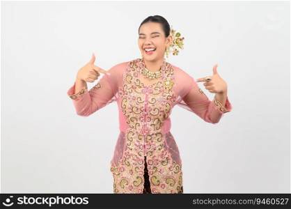 Portrait Young beautiful woman dress up in local culture in southern region with charming gesture smile and point finger two hands on white background, copy space