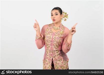Portrait Young beautiful woman dress up in local culture in southern region with charming gesture smile and point finger two hands on white background, copy space