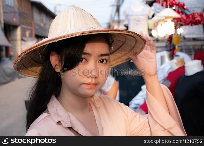 Portrait young beauty Asian woman wearing straw Vietnamese hat with smiley face on blurred background