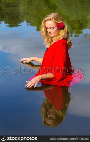 Portrait young blonde caucasian woman standing in lake